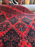 Close-up of intricate medallions and tribal motifs on vintage Afghan rug.