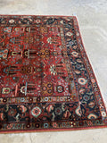 Heriz rug showing strong contrast between rust field and midnight border.