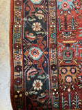 Midnight blue border of antique Heriz rug with turtle motifs and floral elements.