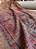 Close up view of tribal motifs and aged dyes with a floppy handle.