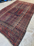 Antique Persian rug with tribal motifs and aged dyes.
