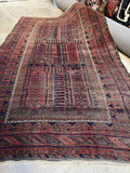 Full view of antique Baluch rug with visible wear.