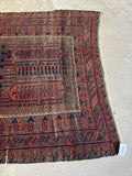 Tribal motifs detail on antique Baluch rug showing aged vegetable dyes.