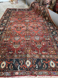 Full view of antique Persian Heriz with wild botanical motif arrangement.