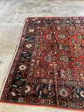 Detail of Heriz rug’s marbled terracotta field and decorative motifs.