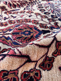 Antique Persian Sarouk area rug detailed view highlighting the thick texture and vegetable-dyed color variations.