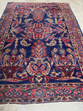Antique Persian Lilihan rug with navy field and jewel toned floral sprays.
