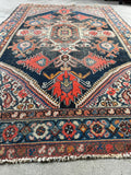 1920s antique Kurdish rug featuring a dark central medallion, saturated vegetable dyes, and vibrant red tribal motifs.