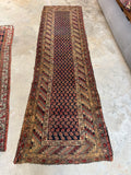 Vintage Persian Kurdish hallway runner featuring repeating flame boteh pattern on dark blue ground.