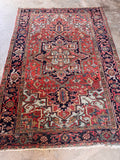 Antique Persian Heriz rug 1920s full view showing madder rust field, geometric central medallion, and ice blue corner spandrels.