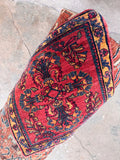Vintage hand knotted wool rug with full pile and rich carmine vegetable dyes.