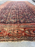 Handwoven Persian rug with vegetable dyed wool in navy, rust, and ivory tones.