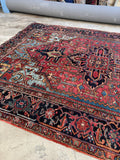 Heriz rug 7’ x 9’9 showing abrash across sky blue and red field with wool texture.