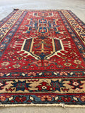 1920s Persian Heriz rug featuring a warm wheat border with symbolic star motifs.