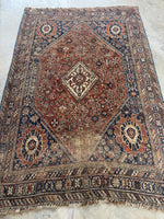 Antique Persian Shiraz rug from the 1920s with large central medallion and tribal motifs.