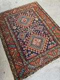 Old Persian Gharajeh scatter rug with navy ground, natural vegetable dyes, scorpion medallion, and rustic wear on the ends.