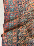 Authentic antique Persian wool rug featuring a repeating village design, naturally aged patina, and soft timeworn colors.