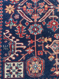 Close-up of stylized botanical motif on navy blue ground.