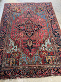 Vintage Persian Heriz rug 7’ x 9’9 with tribal geometric design and strong central medallion.