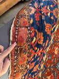 Small repair patch on antique Persian rug edge.