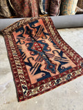 Full view of antique 1920s Persian tribal rug with abrash pink field.