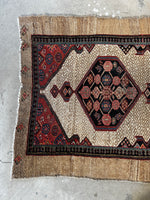 One end view of 1920s Persian runner featuring medallions.
