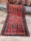 Durable wool antique rug styled on concrete floor highlighting full central field design.