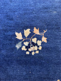 Vintage Chinese blue area rug close-up of natural age-related wear, low pile depth, and exposed foundation threads.