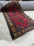 1930s antique Persian Sarouk rug displaying a rich berry red field and detailed floral spray motifs.