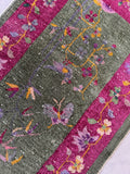 Hand knotted 1930s Art Deco rug with a fuchsia border and wandering floral vine pattern.