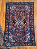 Antique 1930s Persian Dargazin rug with vibrant floral medallion and charcoal border.