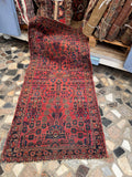 Antique 1930s Persian Sarouk rug with red ground and floral spray motifs.