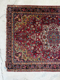 Close-up detail showing intricate hand-knotted floral design and spandrels on low wool pile.