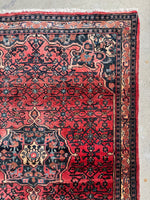 Corner of Bidjar rug showing decorative botanical border bands.