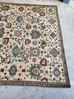 Ivory ground rug with interlocked design and rich colors.