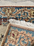 Underside view of an antique small Persian rug handwoven with a floral design .