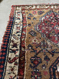 Small antique Caucasian rug with worn low pile and camel tones