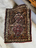 Mini vintage tribal rug with red medallions on a camel ground