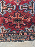 small persian vintage scatter rug with tribal and powerful motifs on a full wool pile