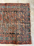 1920s antique Persian handmade rug with restored areas, worn patina, and timeless farmhouse appeal for collected interiors.