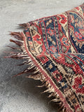 5x6 vintage tribal rug with distressed surface, low wool pile, and softened century old colors.