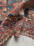 5x6 worn Afshar tribal rug corner detail showing hand knotted construction and age related wear.