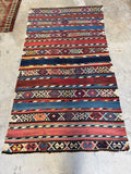 Handwoven kilim rug wall hanging featuring authentic 1920s vintage geometric patterns.