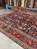 9x12 navy blue Persian wool rug with a geometric all over pattern and a rich rust border.