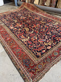 9x12 navy blue antique Persian Heriz rug with rust border in a hand-knotted vegetable-dyed wool design from the 1920s.