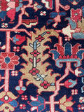 Close up of 9x12 navy blue hand-knotted Heriz rug with vegetable-dyed wool and authentic vintage character.