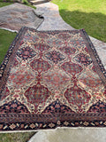 Antique Persian Kerman Lavar rug from the 1880s with an ivory field, lattice design, botanical motifs and rich vegetable dyed colors.