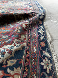 Antique Kerman Lavar area rug with a finely detailed Persian floral design, ivory field and multiple shades of blue and red.