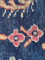 Close up view of floral motifs, aged dyes, and low pile.