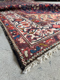 Corner view of Persian floral rug.